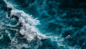 Aerial view to waves in ocean Splashing Waves. Blue clean wavy sea water. Bali, Indonesia.
